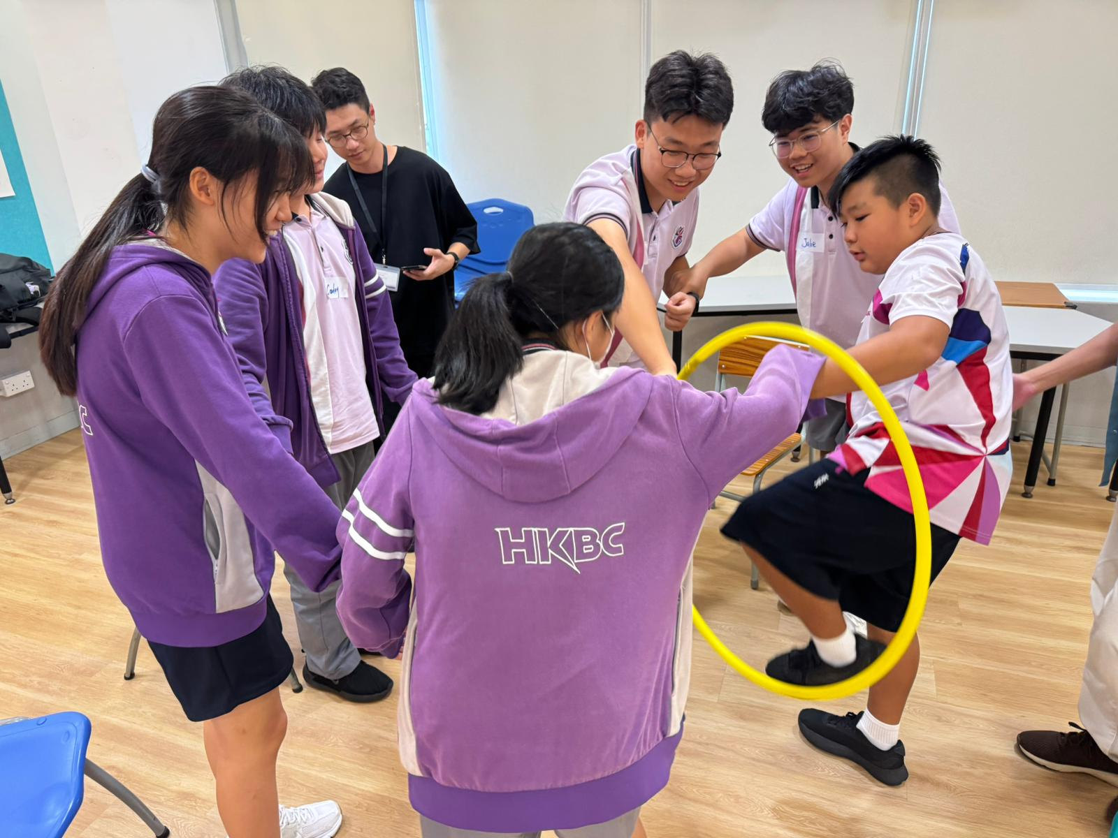 學生在團隊活動中合作傳遞黃色圓環。